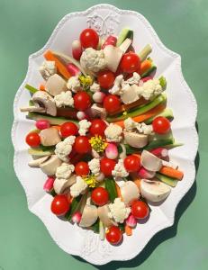 a white plate filled with vegetables on a table at Le Relais Notre Dame in Quinson