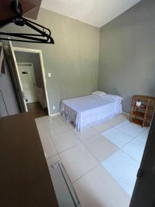 a bedroom with a bed and a tiled floor at Pousada Vila Pitanga in Santos