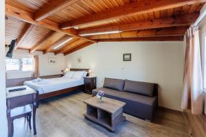 a bedroom with a bed and a couch and a table at Liston Suites in Corfu Town
