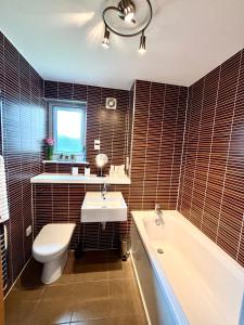 a bathroom with a sink and a tub and a toilet at Golf View in Prestwick +24 photos