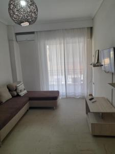 ein Wohnzimmer mit Couch und großem Fenster in der Unterkunft Elegant Home in Nea Iraklitsa