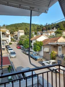 einen Balkon mit Blick auf eine Straße mit parkenden Autos in der Unterkunft Elegant Home in Nea Iraklitsa