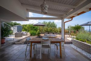 an outdoor patio with a wooden table and chairs at TerraCieloMare Apartments in Monopoli