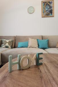 a living room with a couch and a table with the word love at Venima luxury Seaview Pine Apartment in Tivat