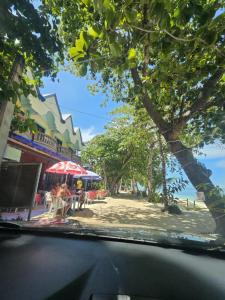 Blick auf eine Straße mit Menschen, die unter einem Baum sitzen in der Unterkunft Trudis Place Beach Resort and Restaurant in Panglao