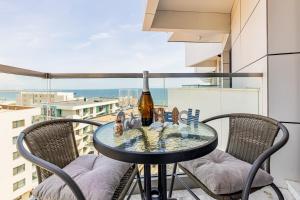 a table with a bottle of wine on a balcony at Miramar - Alezzi Infinity Beach Resort in Năvodari