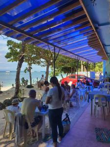 邦劳Trudis Place Beach Resort and Restaurant的一群坐在海滩桌子上的人