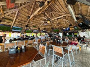 ein Restaurant mit Holztischen und Stühlen und einer Bar in der Unterkunft Relaxing Escape Oceanfront Pool Gem On The Beach in Fort Lauderdale