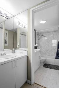 ein Badezimmer mit Waschbecken, Toilette und Spiegel in der Unterkunft Relaxing Escape Oceanfront Pool Gem On The Beach in Fort Lauderdale