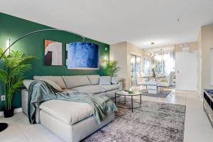 ein Wohnzimmer mit einem Sofa und einer grünen Wand in der Unterkunft Relaxing Escape Oceanfront Pool Gem On The Beach in Fort Lauderdale