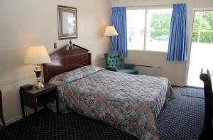 a hotel room with a bed and a chair at Diamond Motor Inn in Owen Sound