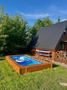 basen w ogrodzie obok domu w obiekcie Domki nad Narwią w mieście Dzierzenin
