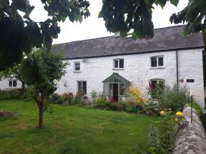 una casetta bianca con un giardino davanti di Ty Gwyn Farmhouse a Brecon