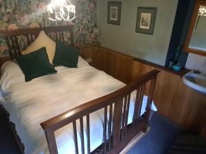 un letto con cuscini verdi in cima a una scala di Ty Gwyn Farmhouse a Brecon