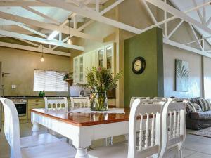 a dining room with a table and chairs and a kitchen at Rondebossie Farm Retreat in Magoebaskloof