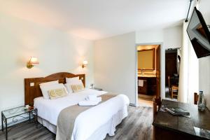 Ein Bett oder Betten in einem Zimmer der Unterkunft Logis Hôtel Etchemaïté