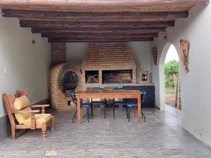 Un comedor con mesa y sillas y chimenea. en Bodega y Alojamiento Don Vega 2, en Tinogasta
