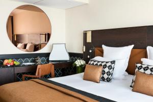 a bedroom with a large bed and a mirror at Hôtel Barrière Le Gray d'Albion in Cannes +37 photos