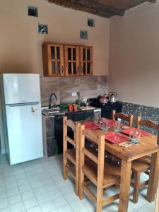 cocina con mesa de madera y nevera blanca en Bodega y Alojamiento Don Vega 2, en Tinogasta