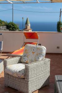 una sedia in vimini seduta sopra un balcone di La Lucciola ad Amalfi