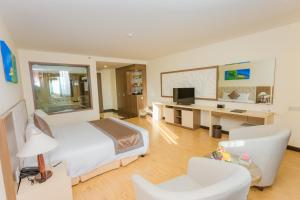 a hotel room with a bed and a desk and chair at Muong Thanh Grand Quang Nam in Tam Ky