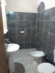 Un baño con un inodoro blanco y un lavabo. en Bodega y Alojamiento Don Vega 2, en Tinogasta
