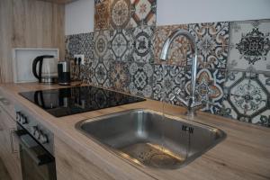 un fregadero de acero inoxidable en una cocina con azulejos en Vakantiehuis in de polder, en Lewedorp 4 fotos más