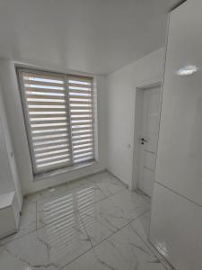 an empty white room with a window and a door at Filip residence in Cluj-Napoca