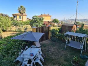 MontariceにあるItalian Experience- Il Colle Sul Mare Holiday Homeのテーブルと椅子と傘のあるパティオ