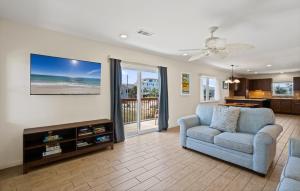a living room with a blue couch and a view of the ocean at Keepin' It Reel Beach House in Pensacola Beach
