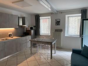 a kitchen with a table and chairs in a room at Appartamento Al Vicolo in Levico Terme
