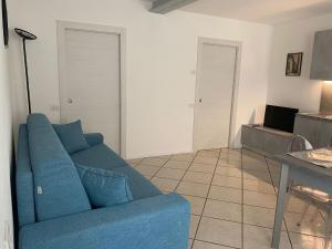 a living room with a blue couch and a table at Appartamento Al Vicolo in Levico Terme