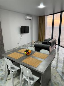 バトゥミにあるTropical garden apartmentsのテーブルとソファのあるダイニングルーム