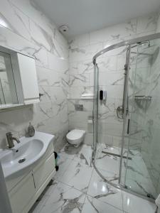 バトゥミにあるTropical garden apartmentsのシャワー、洗面台、トイレ付きのバスルーム +6枚の写真