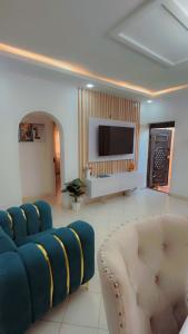 a living room with a blue couch and a tv at Royal Dutchess Luxurious Stay Bamburi in Bamburi