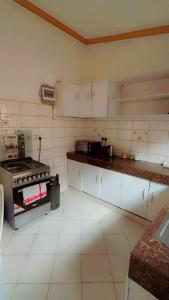 a kitchen with a stove and white cabinets at Royal Dutchess Luxurious Stay Bamburi in Bamburi
