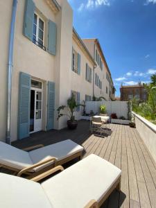 a patio with chairs and tables in front of a building at LILOU in Hyères