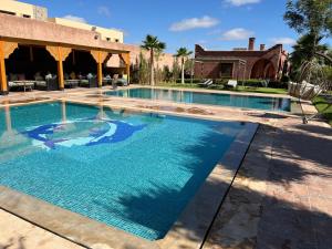 a large swimming pool with blue water at Chez Mamouchthka in Ourika