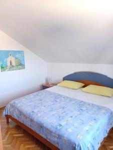 a bedroom with a bed with a blue comforter at Apartmani Saška 2 in Privlaka