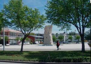 a person walking past a stone monument in a park at MB Apartman in Čapljina