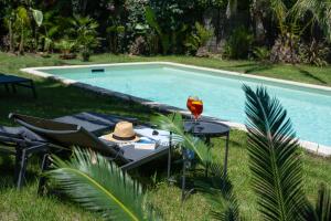 a table with a wine glass next to a swimming pool at La ferme Saint-Antoine in Gassin