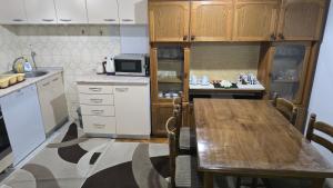 a kitchen with a wooden table and a microwave at Sara Family Home in Struga +15 photos