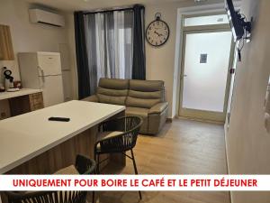 a kitchen and living room with a couch and a table at L'Escale in Bonifacio