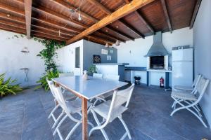 a kitchen with a table and chairs in a room at Villa Macher Piscina y Bar piscina in Tías