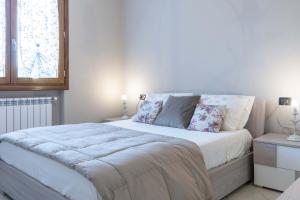 a bedroom with a large white bed with two pillows at Italian Experience- Cuore Toscano in Ponte di Masino
