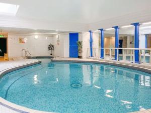a large swimming pool with blue water in a building at Strathmore apt Scarborough, pool, gym, parking in Scarborough