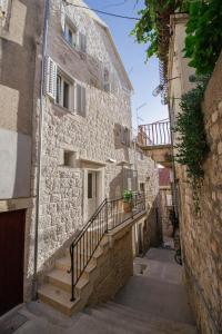 an alley in an old stone building with stairs at Heritage House Kaleta in Hvar