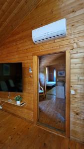 a wooden cabin with a room with a tv and a ceiling at Chalet Villa Mosquito in Silves