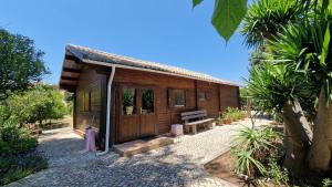 a wooden cabin with a bench in front of it at Chalet Villa Mosquito in Silves