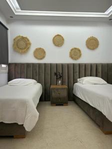 a bedroom with two beds and baskets on the wall at Almina house in Tetouan